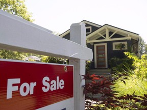 FILE - Home sales in the Vancouver area tumbled 26 per cent in August compared to the same month last year, as observers say a new tax on foreign buyers accelerated a cooling trend in the market. A for sale sign is pictured outside a home in Vancouver in a June, 28, 2016, file photo.
