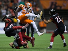 B.C. Lions' Stephen Adekolu, centre, collides with Ottawa Redblacks' Forrest Hightower, left, Antoine Pruneau, bottom, and Jerrell Gavins, back, after making a reception as Mitchell White, right, watches during the second half of a Saturday's game at B.C. Place.