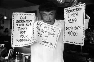 Frank Baker with signs regarding the theft of food from his popular 1,200 seat smorgasbord restaurant, The Attic, in West Vancouver. Baker was also a Vancouver alderman. September 18, 1974.