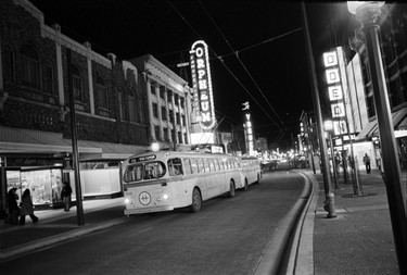 With electric trolley buses and neon signs as a backdrop, Granville Street glows at night. January 3, 1975.