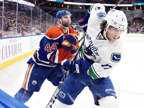 Vancouver Canucks' Ben Hutton (27) and Edmonton Oilers' Zack Kassian (44) battle for the puck during first period NHL pre-season action in Edmonton, Alta., on Saturday October 8, 2016.