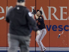 Baltimore Orioles' Hyun Soo Kim gets under a fly ball as a beer can sails past him during seventh inning American League wild-card game action against the Toronto Blue Jays in Toronto, Tuesday, Oct. 4, 2016.