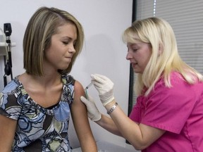 A girl winces as she has her third and final application of the HPV  vaccine.