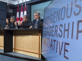 Liberal MP for Northwest Territories, Michael McLeod, right, and members of the Indigenous Leadership Initiative listen to advisor Miles Richardson speak during a news conference in Ottawa on Monday.