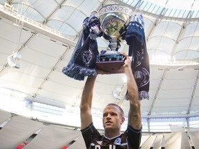 Vancouver Whitecaps' captain Jay DeMerit hoists the Cascadia Cup before a MLS soccer game against the Colorado Rapids in Vancouver, B.C., on Sunday October 27, 2013. The trophy was created by fans of the Vancouver Whitecaps, Seattle Sounders and Portland Timbers and is awarded to the best soccer team in the Pacific Northwest each MLS season.