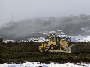 Out of the fog, earth moving equipment keeps going at a steady pace on slope stabilization work in preparation for the construction of the Site C dam.