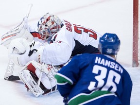 Washington Capitals' goalie Philipp Grubauer, back, of Germany, makes a save as Vancouver Canucks' Jannik Hansen, of Denmark, watches during the second period of an NHL hockey game in Vancouver, B.C., on Saturday October 29, 2016.