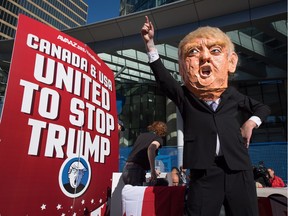 A man wearing an oversized Donald Trump head protests outside the still under construction Trump International Hotel and Tower, during demonstration to encourage U.S. expats across Canada to register and vote, in Vancouver, B.C., on Wednesday October 5, 2016.