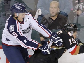 Tri-City Americans defenceman Jeff Rayman (left) takes out the Calgary Hitmen’s Radel Fazleev along the boards during a Western Hockey League game last season in Calgary. Rayman, a Fernie native, was picked up on waivers by the Giants on Monday.