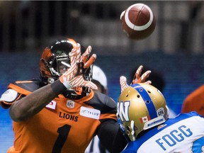 B.C. Lions' Terrell Sinkfield Jr., left, makes a reception as Winnipeg Blue Bombers' Kevin Fogg watches during the first half of a CFL football game in Vancouver, B.C., on Friday October 14, 2016.