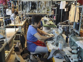 Workers sew Lululemon clothing at the Lululemon Lab in Vancouver. The company has told the House of Commons it may have to move its Vancouver head office to another country because of Canadian rules about temporary foreign workers.