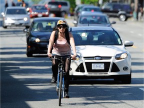 A cyclist travels south on Commercial Drive near 6th Avenue in Vancouver May 16, 2012. The city is considering a dedicated bike lane on the busy east side throughway.