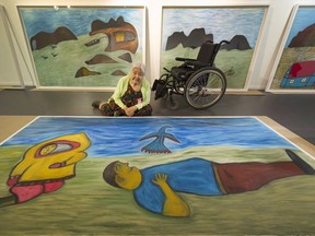 Elisapee Ishulutaq, 91, sits with her art — a suite of four paintings named In His Memory — at the Marion Scott Gallery.