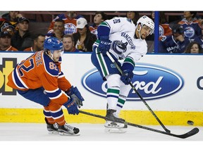 Emerson Etem, who became a father this past week and is now trying to keep his job with the Vancouver Canucks, is shown battling last April with Jordan Oesterle of the Edmonton Oilers.