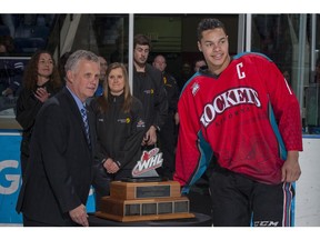 Western Hockey League commissioner Ron Robison, shown presenting the 2014 Scotty Munro Memorial Trophy to then-Kelowna Rockets' captain Madison Bowey, says his league was 'not required' to register as a lobbyist when meeting with government to change the law to exclude WHL players from the definition of 'employee,' making them exempt from employment standards and the minimum wage on the grounds they were 'student athletes.'
