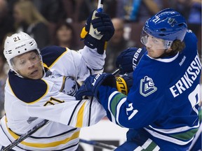 Buffalo's Kyle Okposo pushes Vancouver Canucks forward Loui Eriksson early in a 2-1 win for the Canucks at Rogers Arena on Thursday.