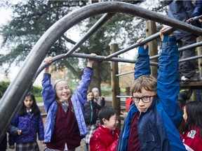 Kids hang out on the monkey bars at Stratford Hall's aging playground in Clark Park in east Vancouver last month. The playground will be replaced thanks to $250,000 raised by students, staff and parents in the neighbourhood.