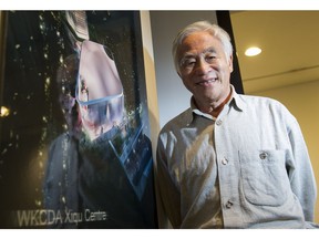 The late Bing Thom poses for a photo in front of a poster of the Hong Kong Xiqu Centre in his Vancouver office on Sept. 25, 2014.