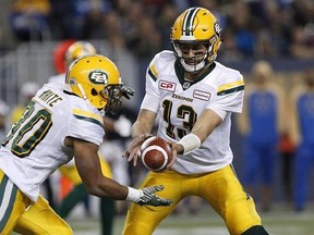 Edmonton Eskimos quarterback Mike Reilly (13) hands off to John White (30) during the first half of CFL action against the Winnipeg Blue Bombers in Winnipeg Friday, September 30, 2016. Edmonton Eskimos running back White and quarterback Reilly and BC Lions receiver Emmanuel Arceneaux were named the CFL&#039;s top performers for the month of October on Thursday. THE CANADIAN PRESS/John Woods