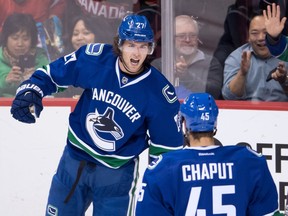 Vancouver Canucks' Ben Hutton, back, and Michael Chaput celebrate Hutton's goal against the Arizona Coyotes during the second period of a pre-season NHL hockey game in Vancouver, B.C., on Monday October 3, 2016.