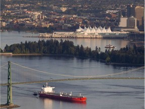 A oil tanker is guided by tug boats as it goes under the Lions Gate Bridge at the mouth of Vancouver Harbour.