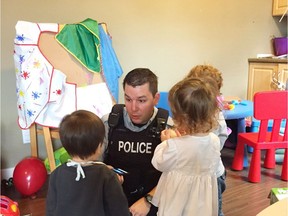 RCMP Cst. Alex Berube plays with children at a daycare in Langford, B.C, in this Nov. 8, 2016 handout photo. Some Mounties on Vancouver Island were put on Play-Doh duty this week after a daycare provider suffered a medical emergency and had to be taken to hospital.