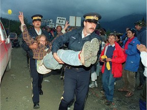 An anti-logging protester is carried away by RCMP officers after being arrested for blocking Macmillan Bloedel logging trucks at the entrance to Clayoquot Valley on July 30, 1993, the summer of the ‘War in the Woods.’