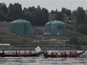 Canoeists paddle past the Kinder Morgan facility in Burrard Inlet in North Vancouver in 2014. There are seven legal challenges facing the company's pipeline expansion, four of them from First Nations.