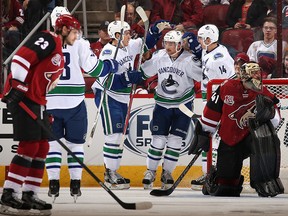 Sven Baertschi #47 (C) of the Canucks is congratulated by his linemates after scoring the opening goal.