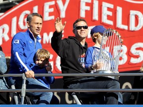 Theo Epstein, president of baseball operations for the Chicago Cubs, waves to the crowd while son Jack and the Commissioner’s Trophy sit on his lap during Friday’s civic parade in Chicago celebrating the Cubs’ World Series championship. After building World Series champions in Boston (where the Red Sox broke an 86-year-old drought to win it all in 2004) and now Chicago (a 108-year drought), what does Epstein do as a third act?