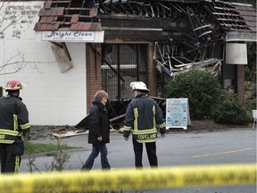 Delta Mayor Lois Jackson, with members of the Delta Fire Department, survey Sunday the aftermath of a blaze Saturday that destroyed three businesses at 93A Avenue and Scott Road in Delta. NICK PROCAYLO/PNG