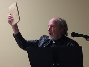 Fr. Charles Brandt, who supports himself as a hermit by restoring ancient books and manuscripts, holds up an antiquarian collection of the teachings of the Desert Fathers, the first Christian hermits from 1,600 years ago.