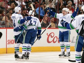 Alexandre Burrows #14 of the Vancouver Canucks celebrates with teammates Sven Baertschi #47 and Bo Horvat #53 after his second period goal against the Arizona Coyotes at Gila River Arena on November 23, 2016 in Glendale, Arizona.