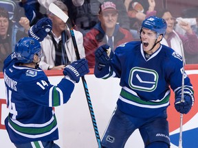 Vancouver Canucks' Bo Horvat, right, celebrates his goal against the Chicago Blackhawks with teammate Alex Burrows during the second period of an NHL hockey game in Vancouver on Nov. 19, 2016.