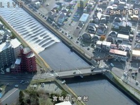 A minor tsunami races up the the Sunaoshi River in Tagajo, Miyagi prefecture, northern Japan, after a strong earthquake on Tuesday.