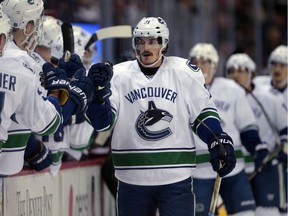 Vancouver Canucks players congratulate left wing Loui Eriksson (21) after his goal against the Colorado Avalanche during the first period of Saturday's game in Denver.
