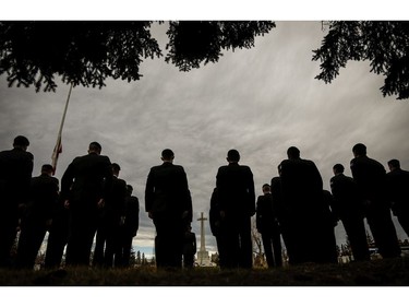 Members of the military stand at attention at a military cemetery during a Remembrance Day service in Calgary, Friday, Nov. 11, 2016.T