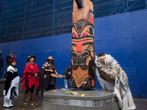 First Nations people gather around The Survivors Pole after it was raised in the Downtown Eastside Saturday November 5.