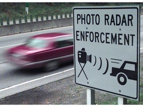 Vehicles drive past a sign on the Upper Levels Highway that warns of the presence of photo radar in North Vancouver in 1997.