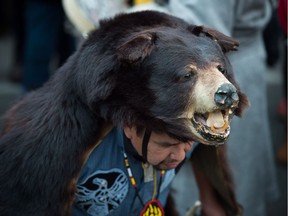 Thomas Terry of the St'at'imc First Nation wears a black bear hide Nov. 19 in Vancouver during a protest march against the Kinder Morgan Trans Mountain Pipeline expansion.