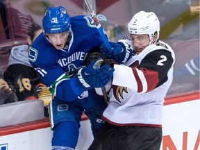 Arizona Coyotes' Luke Schenn, right, checks Vancouver Canucks' Troy Stecher during the third period of a pre-season NHL hockey game in Vancouver, B.C., on Monday October 3, 2016.