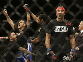 FILE: Danny Castillo, right, reacts as Tony Ferguson, second from left, has his arm raised in victory by referee Herb Dean after a lightweight mixed martial arts bout at UFC 177 on Aug. 30, 2014.