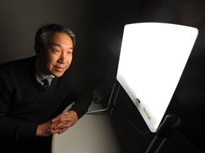Dr. Raymond Lam sits with a light box at UBC's Mood Disorders clinic in Vancouver.