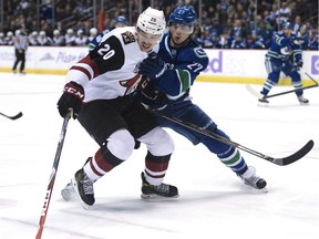 Vancouver Canucks defenceman Ben Hutton (27) fights for control of the puck with Arizona Coyotes centre Dylan Strome (20) during first period NHL action in Vancouver, B.C. Thursday, Nov. 17, 2016.