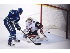 Vancouver Canucks defenceman Ben Hutton (27) scores the game winning goal past Arizona Coyotes goalie Louis Domingue (35) during overtime NHL action in Vancouver, B.C. Thursday, Nov. 17, 2016.