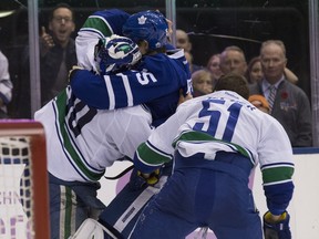 Vancouver Canucks goalie Ryan Miller (30) goes after Toronto Maple Leafs left wing Matt Martin (15) on Saturday November 5, 2016. Craig Robertson/Toronto Sun/Postmedia Network