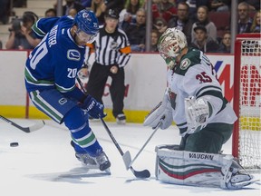 Brandon Sutter looks for the puck in front of Minnesota Wild goalie Darcy Kuemper.