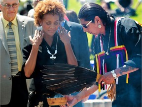 Then-governor general Michaelle Jean participates in a smudging ceremony with Lee Gott from Pine Creek, Man., in Winnipeg in June 2010.