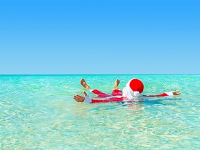 Santa Claus swimming in ocean water, Christmas concept