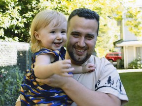 Spencer Walden pictured with his infant daughter in a family handout. Walden, who struggled with mental health issues for many years, was on a medical ward at St. Paulís Hospital when he broke out a window with a fire extinguisher and fell to his death. His family is telling his story.